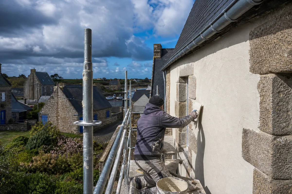 Application d&rsquo;un enduit de finition à la chaux sur une façade en cours de ravalement